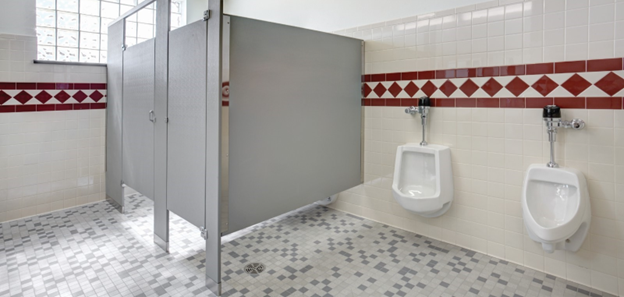 Image of a bathroom. 图片中，卫生间左侧有两个小便池. To the right of the urinals, are two bathroom stalls. Running around the bathroom is a red tile pattern.